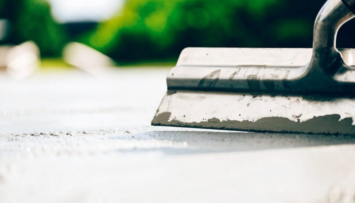 Glättkelle auf frischem grauem Beton – Verarbeitungszeit von Transportbeton