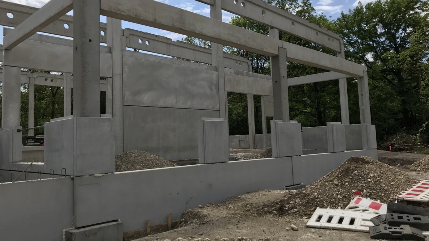 Beton C30/37 im Einsatz: Betonfertigteile einer Halle mit Stützen, Trägern und Wandelementen während der Montage